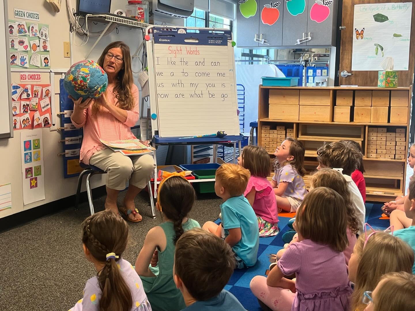 Keep Oconee County Beautiful Director holds globe and talks to young students