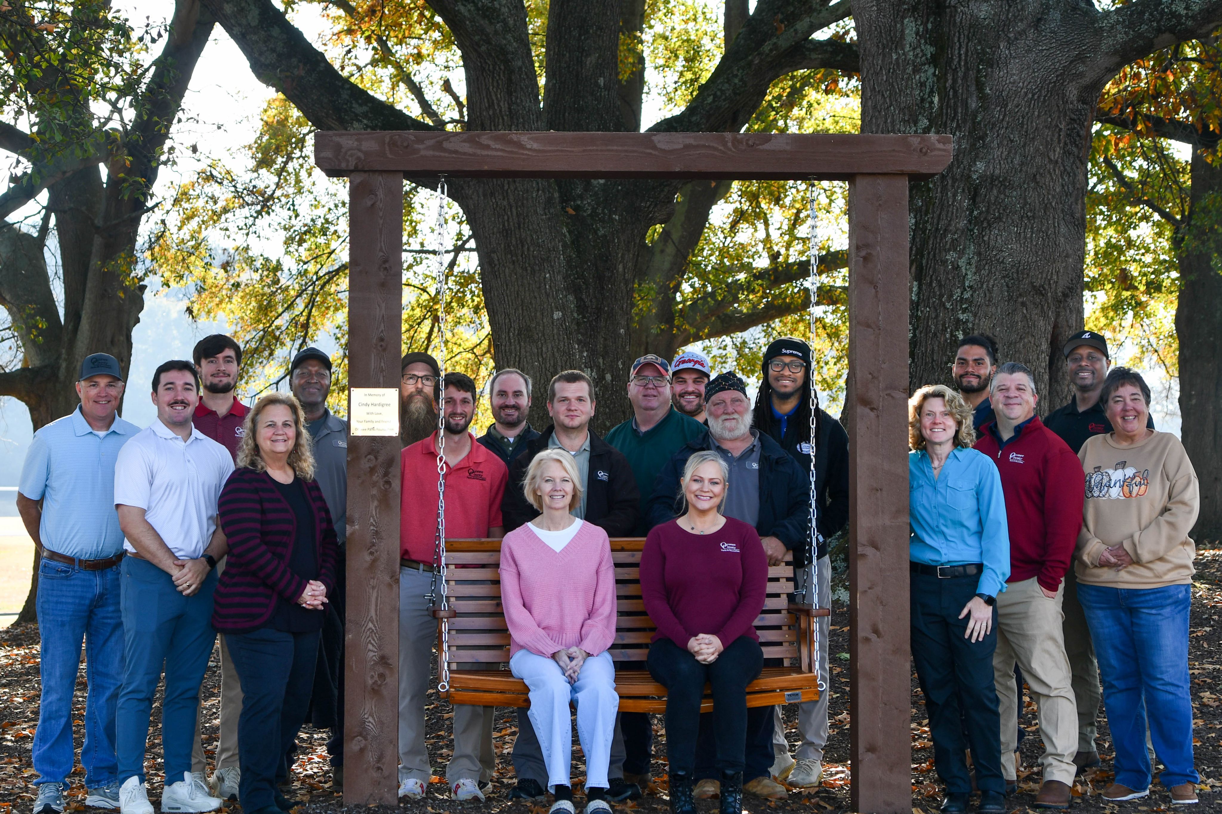 Parks & Recreation staff on and around wooden swing
