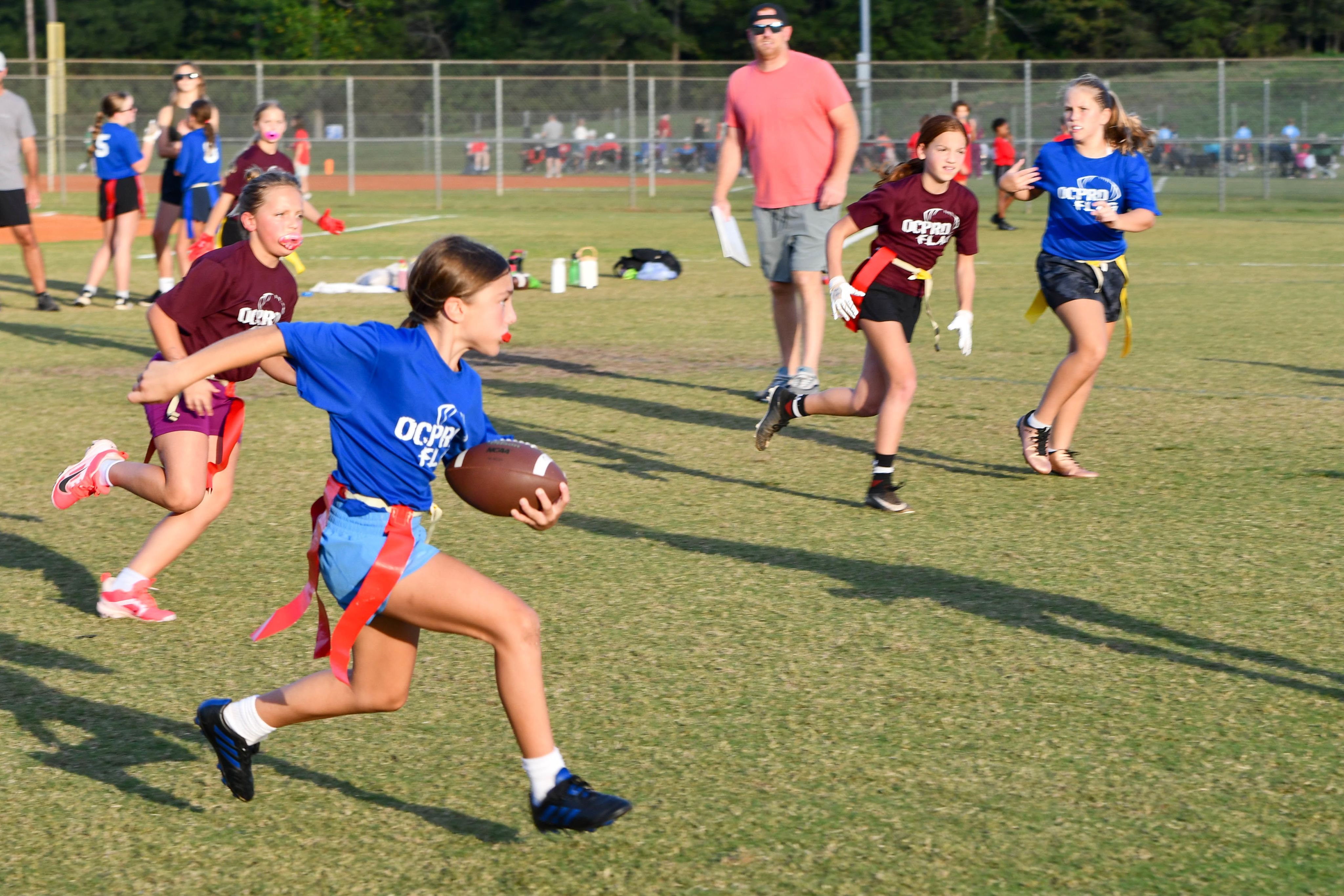 Girl running with the ball in a flag football game