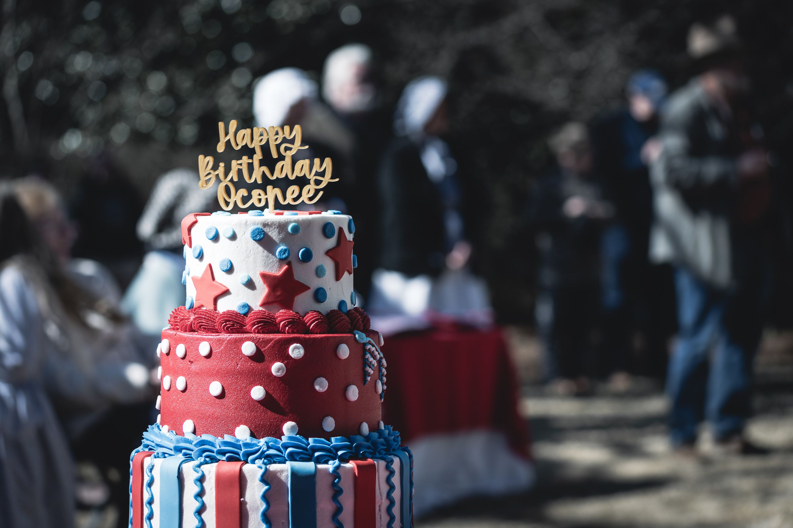 Red white and blue layer cake with a Happy Birthday Oconee topper