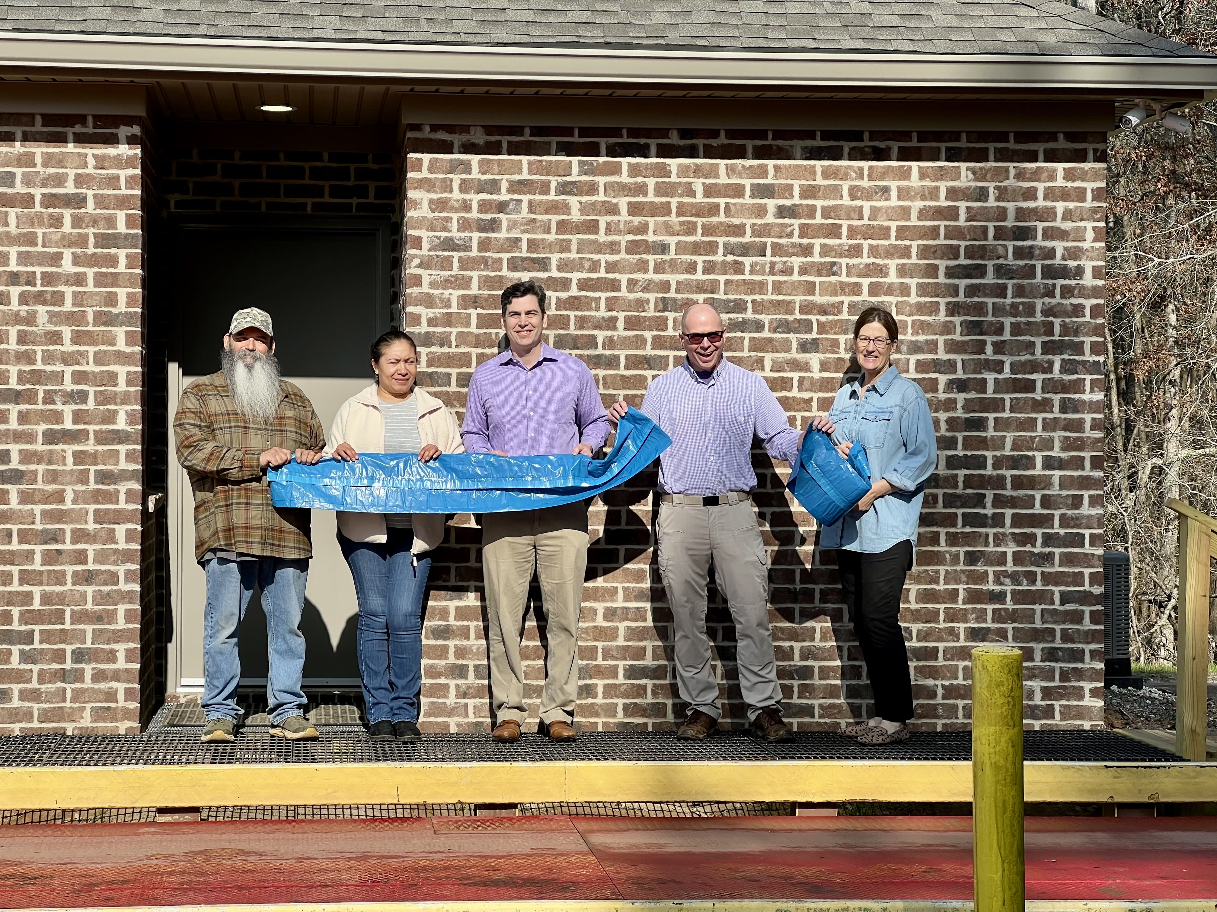 County officials and staff tear blue bag to officially open the new scale house at highway 441 waste and recycling site